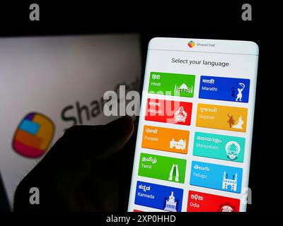 Stoccarda, Germania, 02-11-2022: Persona che detiene il cellulare con il sito web della società indiana Mohalla Tech Pvt Ltd (ShareChat) sullo schermo con il logo. Concentrati Foto Stock