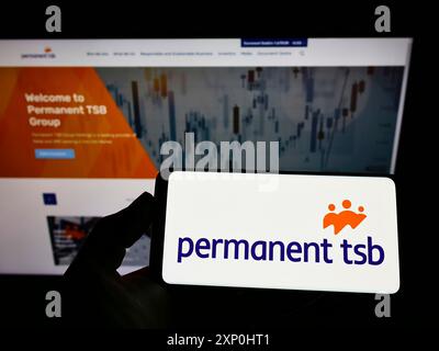 Stoccarda, Germania, 02-06-2022: Persona che detiene uno smartphone con il logo della società irlandese Permanent TSB Group Holdings plc sullo schermo di fronte al sito web. Foto Stock