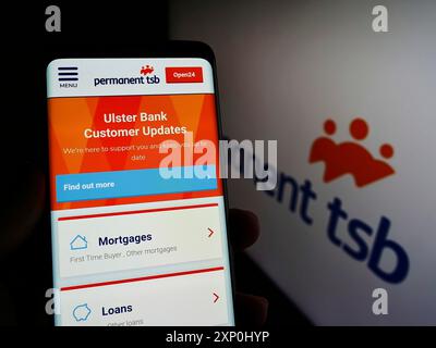 Stoccarda, Germania, 02-06-2022: Persona che detiene uno smartphone con sito web della società irlandese Permanent TSB Group Holdings plc sullo schermo con logo. Concentrati Foto Stock