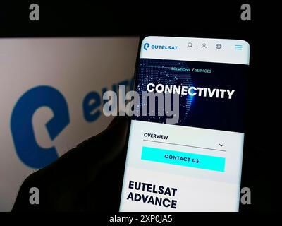 Stoccarda, Germania, 01-30-2022: Persona che detiene il cellulare con pagina web della società satellitare francese Eutelsat SA sullo schermo davanti al logo. Concentrati su Foto Stock