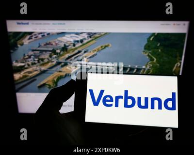 Stoccarda, Germania, 01-09-2022: Persona che detiene il cellulare con il logo della società elettrica austriaca Verbund AG sullo schermo di fronte alla pagina web aziendale. Foto Stock
