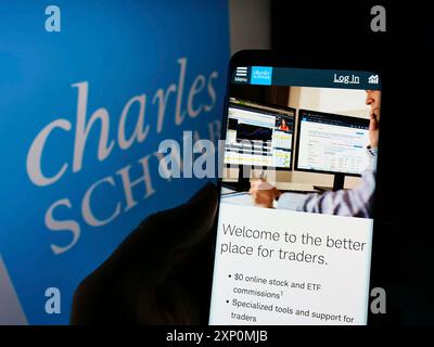 Stoccarda, Germania, 01-06-2022: Persona che detiene uno smartphone con pagina web della società finanziaria Charles Schwab Corporation sullo schermo con logo. Concentrati Foto Stock