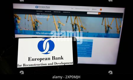 Stoccarda, Germania, 01-06-2022: Persona che tiene un cellulare con il logo della Banca europea per la ricostruzione e lo sviluppo (BERS) sullo schermo con pagina web. Foto Stock