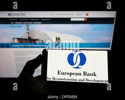 Stoccarda, Germania, 01-06-2022: Persona che detiene un telefono cellulare con il logo della Banca europea per la ricostruzione e lo sviluppo (BERS) sullo schermo con il web Foto Stock