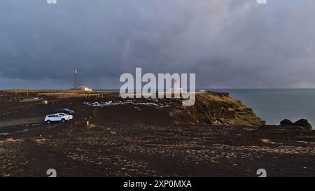 Dyrholaey, Islanda, 03-24-2021: Vista sulla cima della penisola di Dyrholaey sulla costa meridionale dell'Islanda con parcheggio auto e faro in inverno Foto Stock