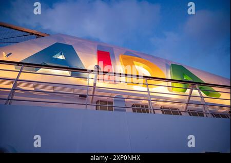 Logo AIDA bella illuminato attaccato a una nave da crociera AIDA durante il cielo nuvoloso, vista dall'angolo basso Foto Stock