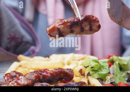 Tradizionale Kofte turco con patatine fritte e insalata sul piatto Foto Stock