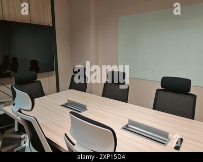 Piccola sala riunioni vuota con televisione e lavagna bianca per la discussione. Camera interna moderna e minimalista. Foto Stock