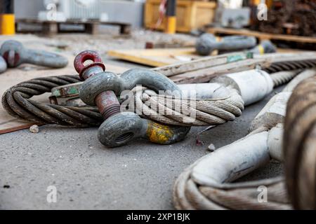 Imbracatura in acciaio per impieghi gravosi con bullone di ancoraggio di sicurezza in siti industriali, ingranaggi di sollevamento. Foto Stock