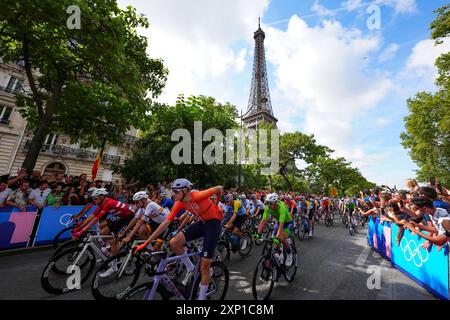 I motociclisti passano davanti alla Torre Eiffel vicino all'inizio della gara maschile su strada l'ottavo giorno dei Giochi Olimpici di Parigi del 2024 in Francia. Data foto: Sabato 3 agosto 2024. Foto Stock