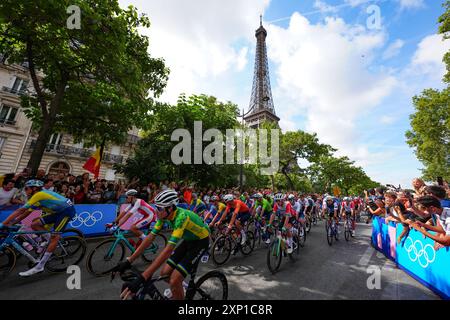 I motociclisti passano davanti alla Torre Eiffel vicino all'inizio della gara maschile su strada l'ottavo giorno dei Giochi Olimpici di Parigi del 2024 in Francia. Data foto: Sabato 3 agosto 2024. Foto Stock