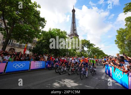 I motociclisti passano davanti alla Torre Eiffel vicino all'inizio della gara maschile su strada l'ottavo giorno dei Giochi Olimpici di Parigi del 2024 in Francia. Data foto: Sabato 3 agosto 2024. Foto Stock