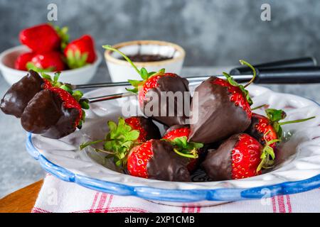 Fragole fresche immerse nel cioccolato fondente Foto Stock