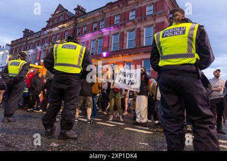 Liverpool, Regno Unito. 02 AGOSTO 2024. La polizia cerca di tenere separate entrambe le parti come manifestanti che si identificano come ala destra, così come membri del SUTR e organizzazioni di sinistra riuniti sui lati opposti della strada fuori dalla moschea Abdullah Quilliam, una delle prime moschee in Inghilterra, sullo sfondo di rivolte in tutto il paese a seguito di un incidente a Southport. A parte alcune urla e alcuni manifestanti che hanno attraversato brevemente i lati, non si sono osservati problemi. Credito Milo Chandler/Alamy Live News Foto Stock