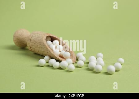 Scoop con rimedio omeopatico su sfondo verde chiaro Foto Stock