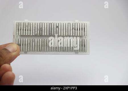 Vista delle strisce di contatto elettriche sul lato posteriore di una breadboard utilizzata per realizzare vari prototipi e testare progetti elettronici Foto Stock