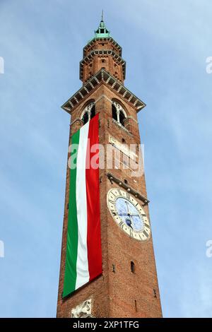 Vicenza, vi, Italia - 10 maggio 2024: Torre dell'orologio chiamata TORRE BISSARA e lunga bandiera italiana Foto Stock