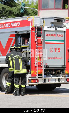 Vicenza, vi, Italia - 23 maggio 2024: Vigili del fuoco in divisa con testo italiano e camion dei pompieri con il numero di telefono 115 Foto Stock