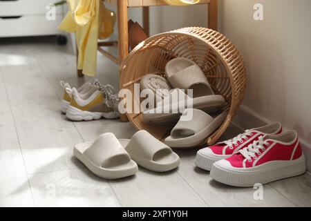 Cestino con pantofole per gli ospiti e scarpe da ginnastica all'ingresso di casa Foto Stock