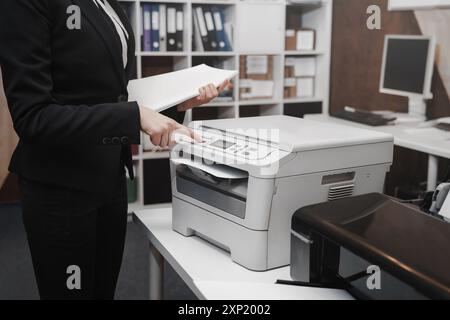 Bussinesswoman premere il pulsante a mano sul pannello della stampante, scanner stampante laser fotocopiatrice per ufficio concetto di avvio Foto Stock