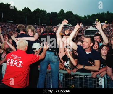 I fan entusiasti fanno il tifo e si godranno un vivace concerto dei Red Hot Chili Peppers a Berlino, 2006. Questa immagine cattura l'energia e l'unità degli eventi musicali dal vivo. Foto Stock