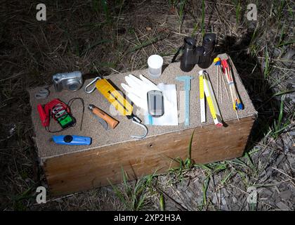 Attrezzatura professionale Wolf utilizzata per il tracciamento dei lupi in Lusazia, Germania, giugno 2011. Vari utensili disposti su una scatola di legno in un ambiente esterno. Foto Stock