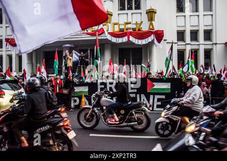 Bandung, Giava Occidentale, Indonesia. 3 agosto 2024. I musulmani indonesiani sventolano la bandiera palestinese e sventolano uno striscione che dice la Palestina libera durante un'azione di solidarietà per il popolo palestinese di fronte all'edificio Merdeka di Bandung, Giava occidentale. Centinaia di musulmani indonesiani hanno partecipato a un'azione di solidarietà per il popolo palestinese dopo l'uccisione del leader politico di Hamas Ismail Haniyeh e della massa di manifestanti condannati per quell'incidente. Questa azione ha coinciso anche con il 300° giorno del genocidio compiuto da Israele in Palestina. (Immagine di credito: © Dimas Rachmatsyah/Pacific Press Foto Stock