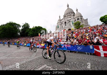 Il gruppo passa davanti alla Basilique du Sacre Coeur de Montmartre durante la gara ciclistica maschile dell'ottavo giorno dei Giochi Olimpici di Parigi del 2024 in Francia. Data foto: Sabato 3 agosto 2024. Foto Stock