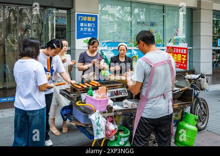 Donne che mangiano cibo di strada a Chengdu, Sichuan, Cina. Foto Stock