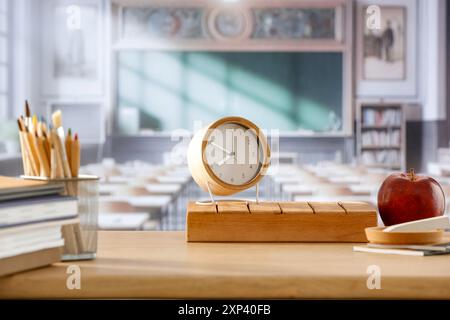 Cose scolastiche e zaino sulla panchina della scuola in classe. Sfondo sfocato della lavagna sulla parete e sulla finestra con luce solare in entrata. Foto Stock