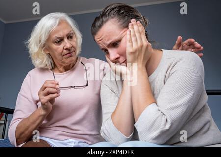 La mamma anziana incoraggia la bambina adulta amata in una situazione di vita difficile. Foto Stock