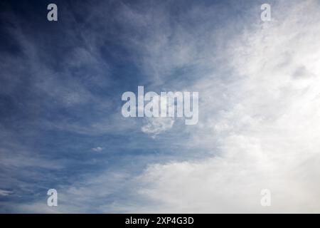 Il cielo è una bella tonalità di blu con soffici nuvole bianche sparse su di esso, creando un tranquillo paesaggio naturale Foto Stock