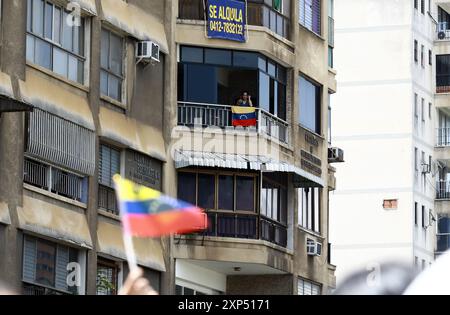 3 agosto 2024, Valencia, Carabobo, Venezuela: 3 agosto, 2024 . Un sostenitore dell'opposizione osserva dal suo appartamento una marcia dell'opposizione nel mezzo delle contese elezioni presidenziali, a Valencia, in Venezuela. Foto: Juan Carlos HernÃndez (immagine di credito: © Juan Carlos Hernandez/ZUMA Press Wire) SOLO PER USO EDITORIALE! Non per USO commerciale! Foto Stock