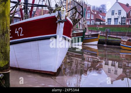 Pittoresco porto, parzialmente ghiacciato, nel villaggio di pescatori di Greetsiel con vecchie barche di gamberi nel freddo periodo di gennaio. Germania, Frisia orientale. Foto Stock