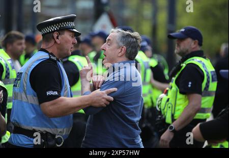 Manchester, Inghilterra, Regno Unito. 3 agosto 2024. Un manifestante nazionalista litiga con gli agenti di polizia che bloccano la strada durante la manifestazione nel centro di Manchester. A seguito dell'omicidio di tre bambini a Stockport, oltre una dozzina di città e città stanno assistendo a manifestazioni e contro-demo razziste in tutto il Regno Unito. Ci sono stati disordini in una serie di incontri. Un uomo di 17 anni è stato arrestato e accusato del suo omicidio (immagine di credito: © Martin Pope/ZUMA Press Wire) SOLO PER USO EDITORIALE! Non per USO commerciale! Foto Stock