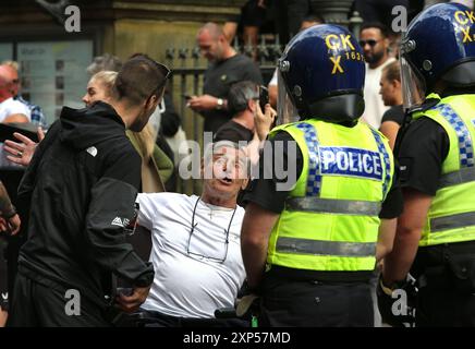 Manchester, Inghilterra, Regno Unito. 3 agosto 2024. Un manifestante nazionalista litiga con gli agenti di polizia che bloccano la strada durante la manifestazione nel centro di Manchester. A seguito dell'omicidio di tre bambini a Stockport, oltre una dozzina di città e città stanno assistendo a manifestazioni e contro-demo razziste in tutto il Regno Unito. Ci sono stati disordini in una serie di incontri. Un uomo di 17 anni è stato arrestato e accusato del suo omicidio (immagine di credito: © Martin Pope/ZUMA Press Wire) SOLO PER USO EDITORIALE! Non per USO commerciale! Foto Stock