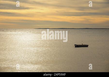 Tranquilla vista sull'oceano con una barca solitaria al tramonto a Piriapolis, Uruguay. Foto Stock