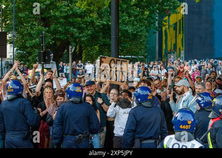 Bristol, Regno Unito. 3 agosto 2024. Gli attivisti anti-razzismo sono ritratti mentre affrontano attivisti di estrema destra a Castle Park, nel centro di Bristol. Negli ultimi giorni sono scoppiate violenze in proteste analoghe di estrema destra in diverse città e città inglesi a seguito di un pugnalamento di massa che ha ucciso tre ragazze. Alla polizia di Bristol sono stati conferiti ulteriori poteri per fermare, perquisire e disperdere le persone al fine di evitare che si verifichino problemi tra il gruppo di estrema destra e i manifestanti anti razzisti che hanno organizzato una contro-protesta. Crediti: Lynchpics/Alamy Live News Foto Stock