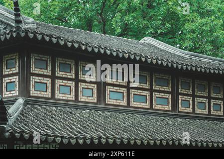 Un tradizionale tetto cinese con dettagli ornati, visto in un giardino di Suzhou. Foto Stock