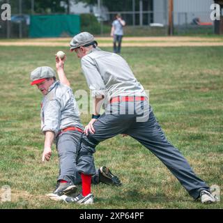 Lambertville, Stati Uniti. 3 agosto 2024. Un Logan First Baseman tagga la base con il piede tenendo in mano il baseball costringendo il corridore Logan a ritirarsi durante una partita di baseball d'epoca tra il Lambertville Logan base Ball Club e il Flemington Neshanock base Ball Club sabato 3 agosto 2024 all'Ely Field di Lambertville, New Jersey. Le squadre fanno parte di una lega vintage di baseball che gioca secondo le regole dell'anno 1866, quando le due squadre si formarono originariamente. Negli ultimi 9 anni le squadre si sono riformate e non usano guanti da baseball per catturare il baseball. Catturano la balena Foto Stock