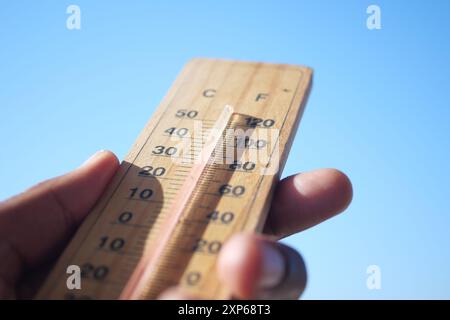 Termometro che misura efficacemente la temperatura in un cielo azzurro chiaro durante il giorno Foto Stock