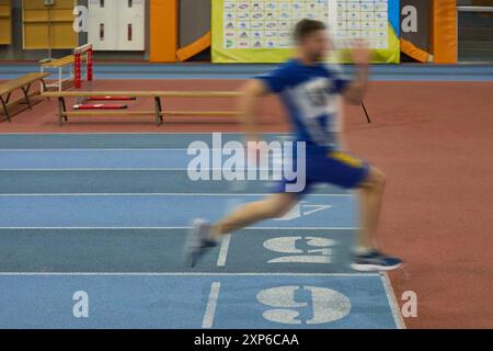 Silhouette di un corridore che attraversa il traguardo. Veterano ucraino ferito che corre la distanza sprint. Kiev - 13 dicembre 2023 Foto Stock