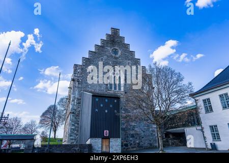 Un sentiero in pietra conduce attraverso una grande porta ad arco verso la storica fortezza di Bergenhus. La torre in stile medievale e le mura in pietra creano un senso di Foto Stock