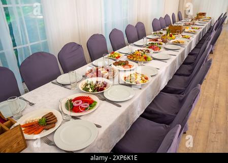 Tavolo festivo con insalate Caesar, barbabietole, piatto di frutta senza persone Foto Stock