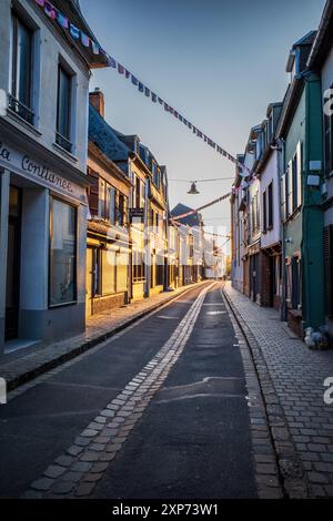 Scena di strada in tarda serata a Saint Valery-sur-somme, Francia. Luce al crepuscolo che illumina le vecchie case. Evocativo. Tramonto. Foto Stock