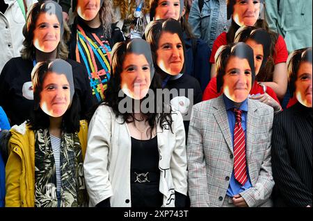 Edimburgo, Scozia, Regno Unito. 4 agosto 2024. Edinburgh Fringe: Un flashmob che indossa le maschere dell'iconica Lynn Benfield, l'assistente di Alan Partridge, sul Royal Mile promuovendo la nuova commedia Lynn Faces della drammaturgo Laura Horton. Mostra alla sala principale di Summerhall, luogo 26, da stasera. Crediti: Craig Brown/Alamy Live News Foto Stock