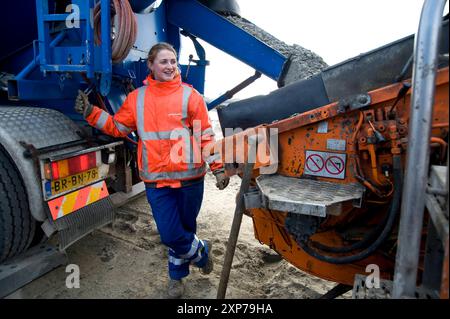 Giovane donna adulta che versa calcestruzzo giovane donna adulta che versa calcestruzzo durante la costruzione di un ponte sull'autostrada A2 ad Abcoude, Paesi Bassi. Abcoude A2 / Abcoude Noord-Holland Nederland Copyright: XGuidoxKoppesxPhotox Foto Stock