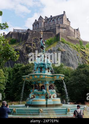 Castello di Edimburgo visto in alto sopra i Princes Street Gardens con la Fontana di Ross a Edimburgo, capitale della Scozia, 3 agosto 2024 Foto Stock