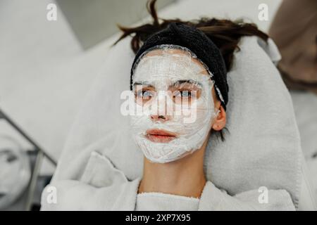 Giovane donna che riceve un trattamento viso alla Spa durante il pomeriggio rilassante Foto Stock