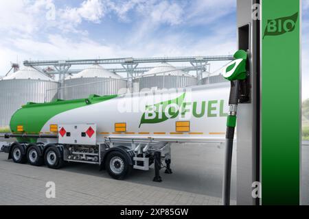 Ugello del carburante con scritta BIO sullo sfondo del rimorchio con biocarburante. Concetto di decarbonizzazione dei biocarburanti a emissioni zero. Foto Stock